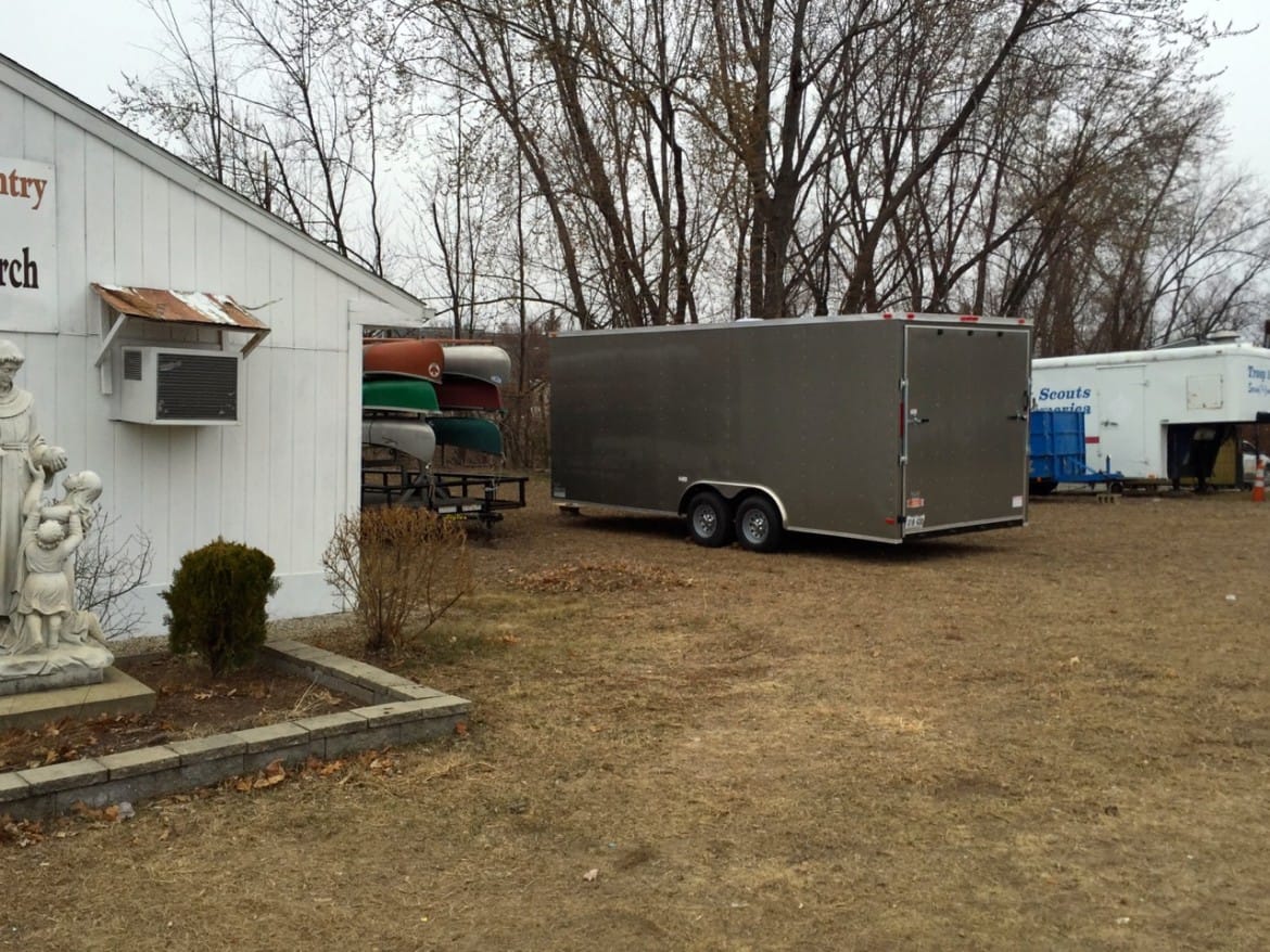 The silver trailer sits next to the Blessed Sacrament food pantry, some kayaks and a Boy Scout trailer.