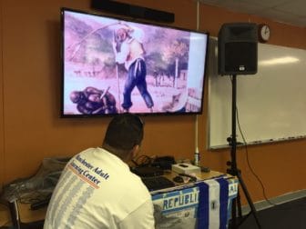 Students watch a video presentation about the history of Puerto Rico.