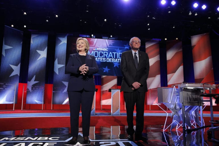 Democratic U.S. presidential candidates Hillary Clinton (L) and Bernie Sanders stand on stage before the start of the Democratic presidential candidates debate sponsored by MSNBC at the University of New Hampshire in Durham, New Hampshire, February 4, 2016. REUTERS/Carlo Allegri - RTX25ISR