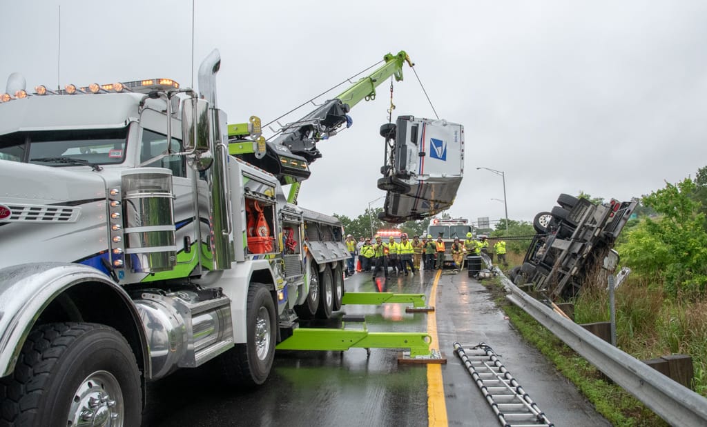 Tow truck hauling mail truck on I-293 rolls over, snarls traffic for 4 hours