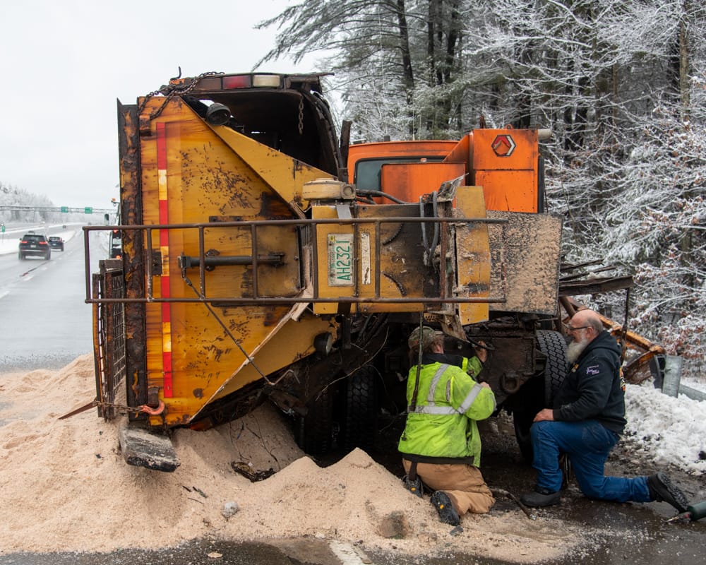 Plow truck hits guardrail, overturns spilling salt and sand on Everett Turnpike