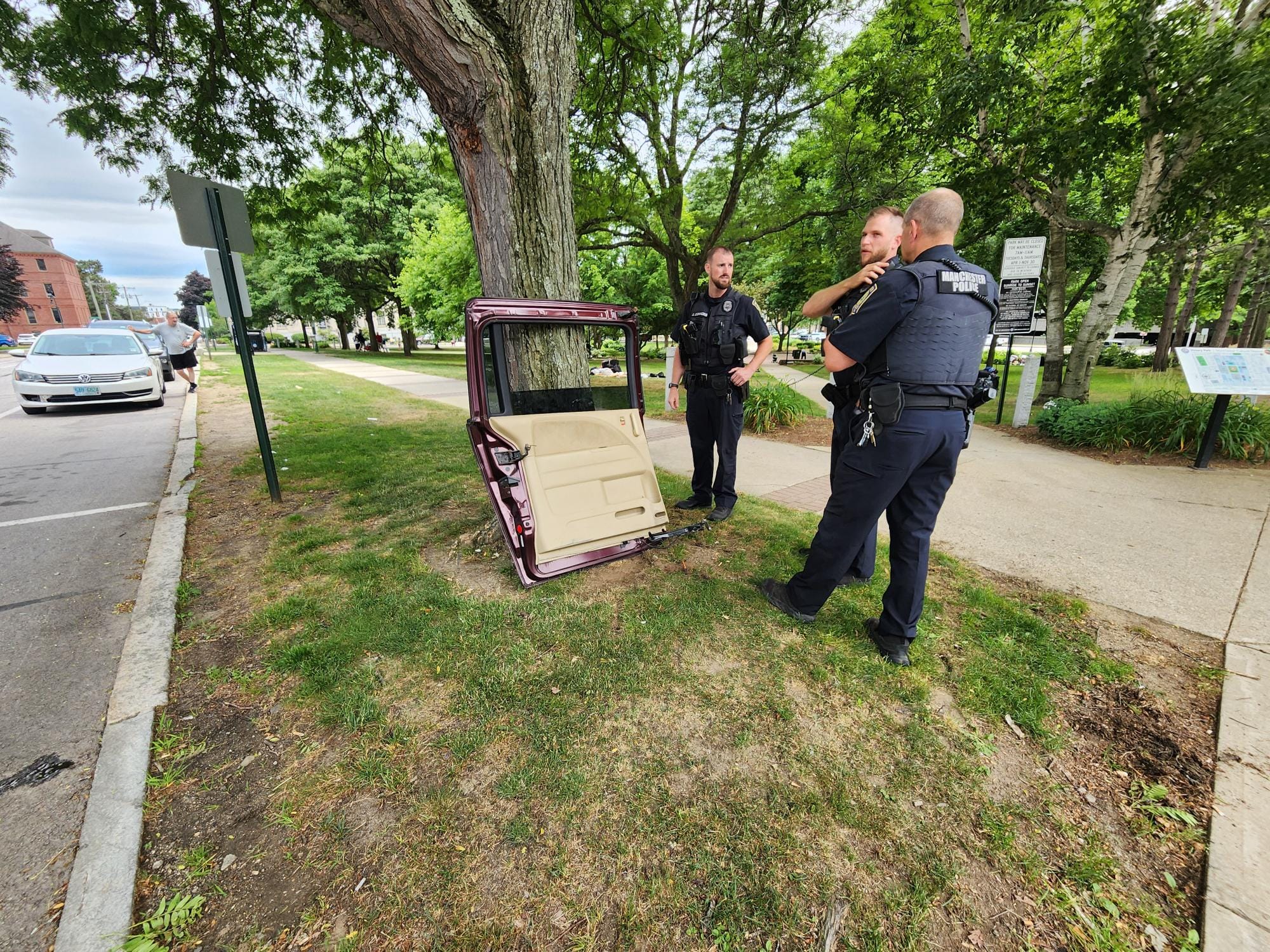 Woman chasing man drives van through park, hits tree, leaves van door behind