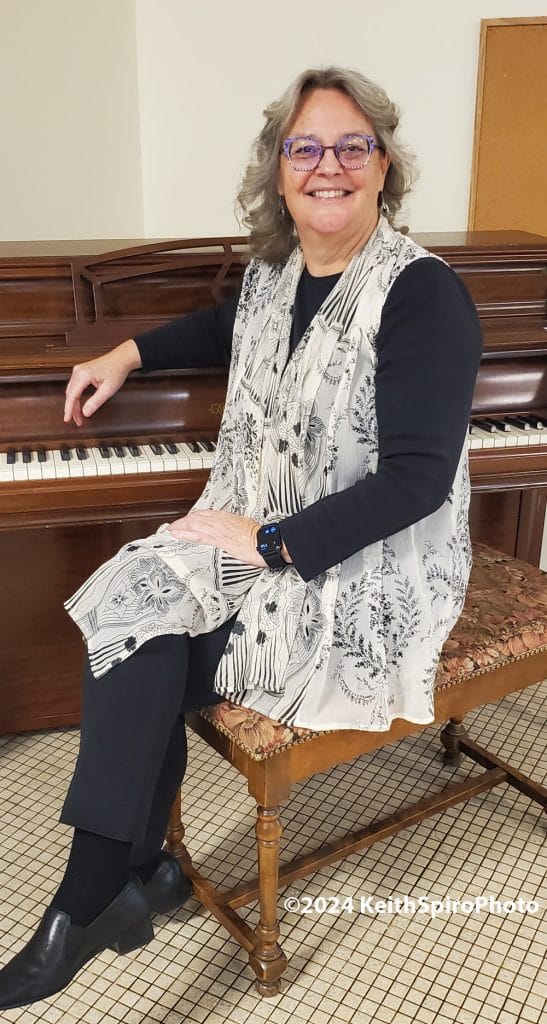 Manchester Community Music School Exec Director Polly Towner sitting at a piano in a photo by Keith Spiro.