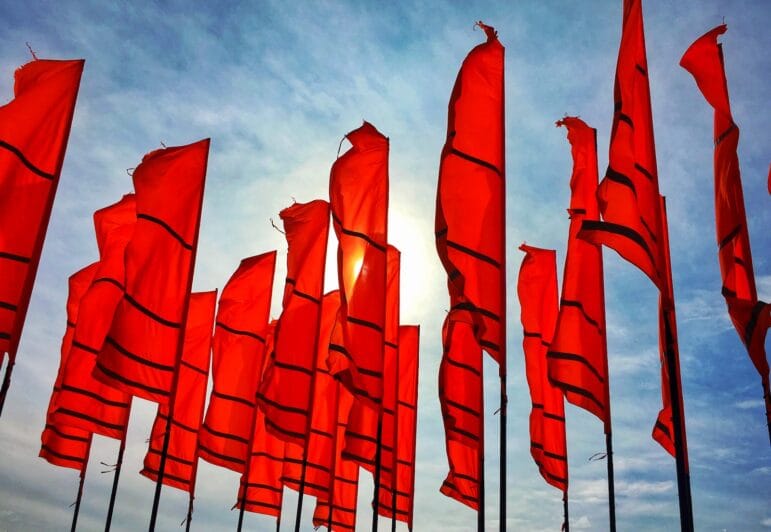 a bunch of red flags flying in the air