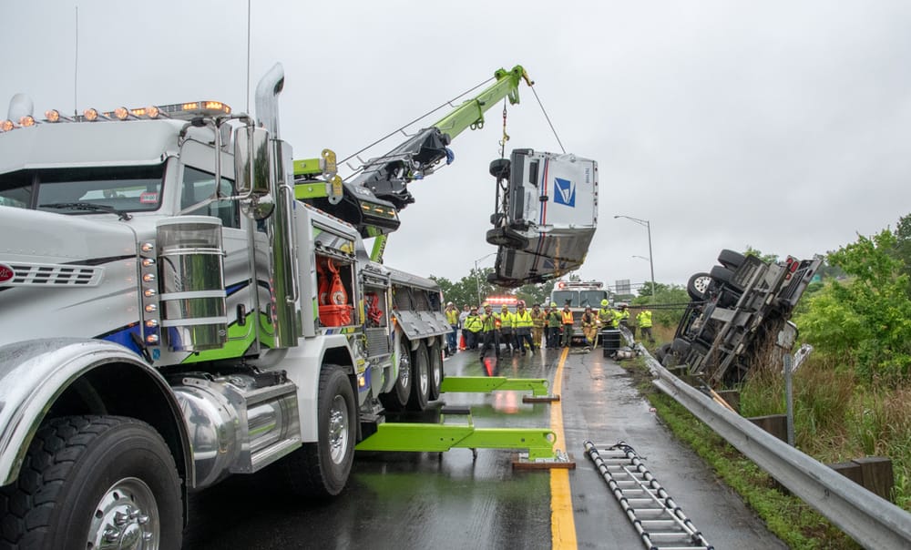 Tow truck hauling mail truck on I-293 rolls over, snarls traffic for 4 hours post image