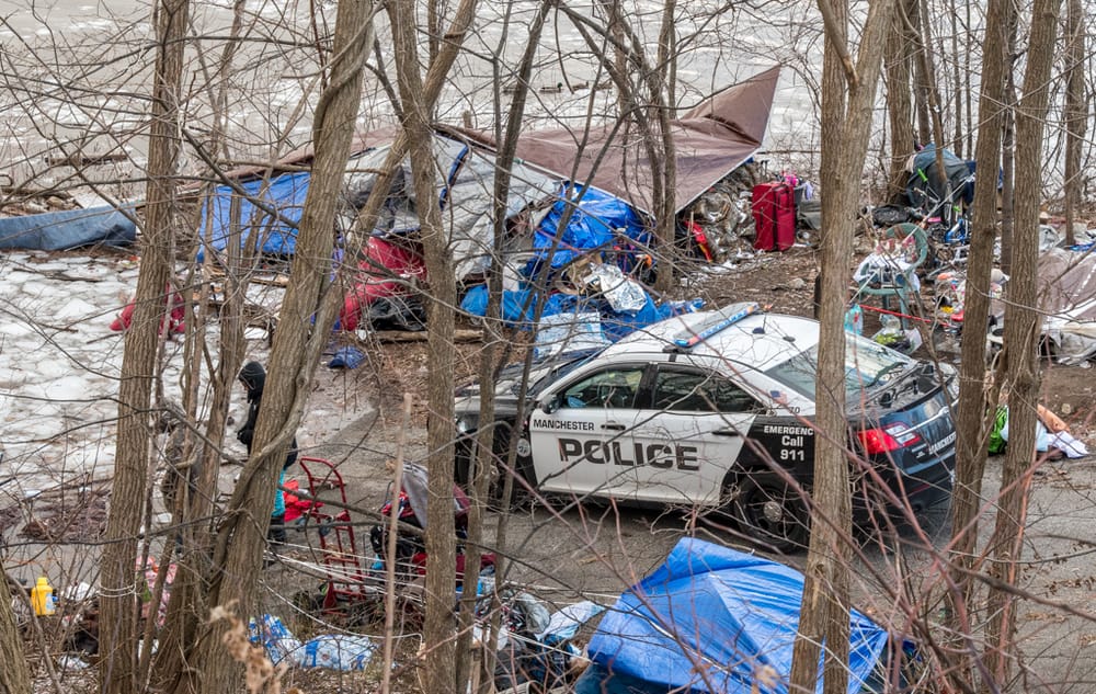 Police release name of man found dead inside car at encampment next to the river post image